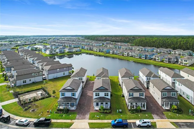 an aerial view of residential houses with outdoor space and swimming pool