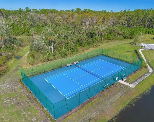 a view of a tennis ground with large trees