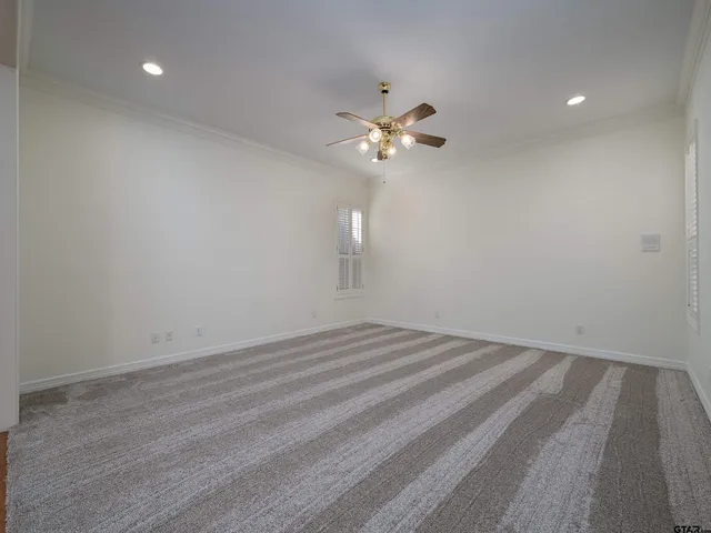 a view of empty room with wooden floor and ceiling fan