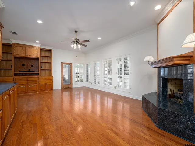 a view of empty room with wooden floor and fireplace