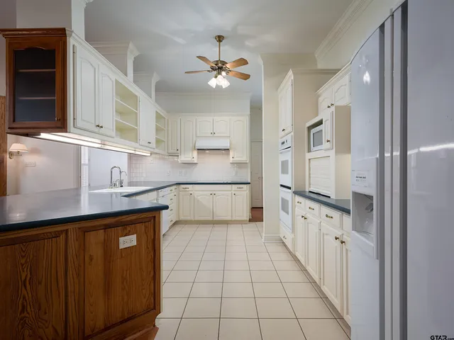 a kitchen with granite countertop a sink counter top space cabinets and stainless steel appliances