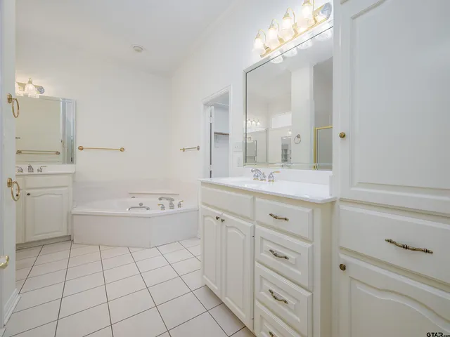 a spacious bathroom with a granite countertop sink a toilet mirror and bathtub