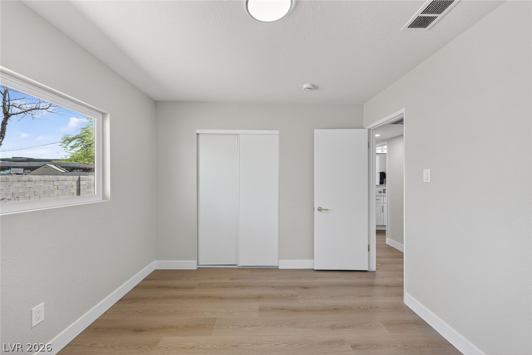2484 Anglia Street Las Vegas, NV 89142 - Photo 18 of 20 This spacious bedroom offers modern flooring and ample natural light, creating a bright and inviting atmosphere.