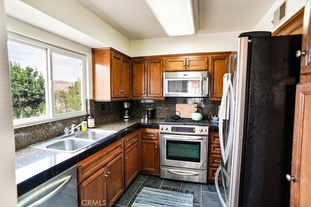 31311 The Old Road, Unit E Castaic, CA 91384 - Photo 6 of 19 a kitchen with a sink stove and refrigerator