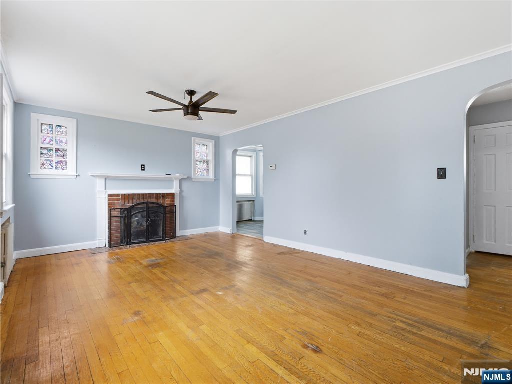 153 Arlington Avenue Paterson, NJ 07502 - Photo 2 of 12 a view of a livingroom with a fireplace and a ceiling fan