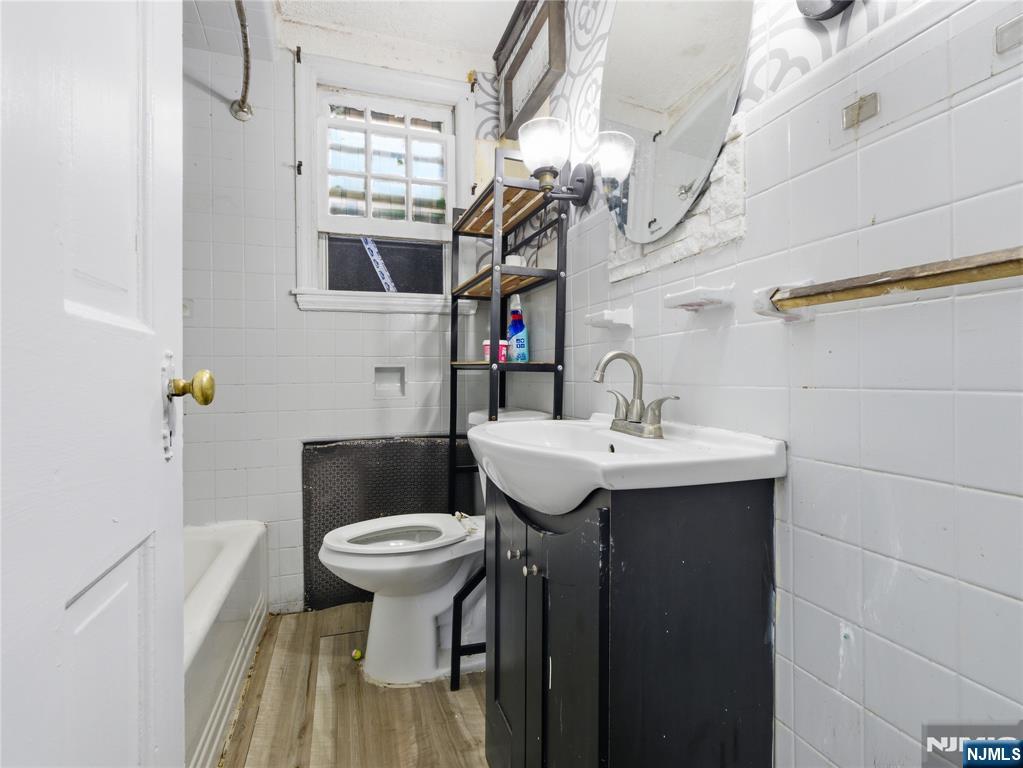 153 Arlington Avenue Paterson, NJ 07502 - Photo 5 of 12 a bathroom with a sink a toilet and mirror