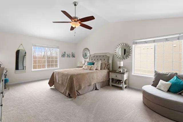 a spacious bedroom with a bed a couch and a window