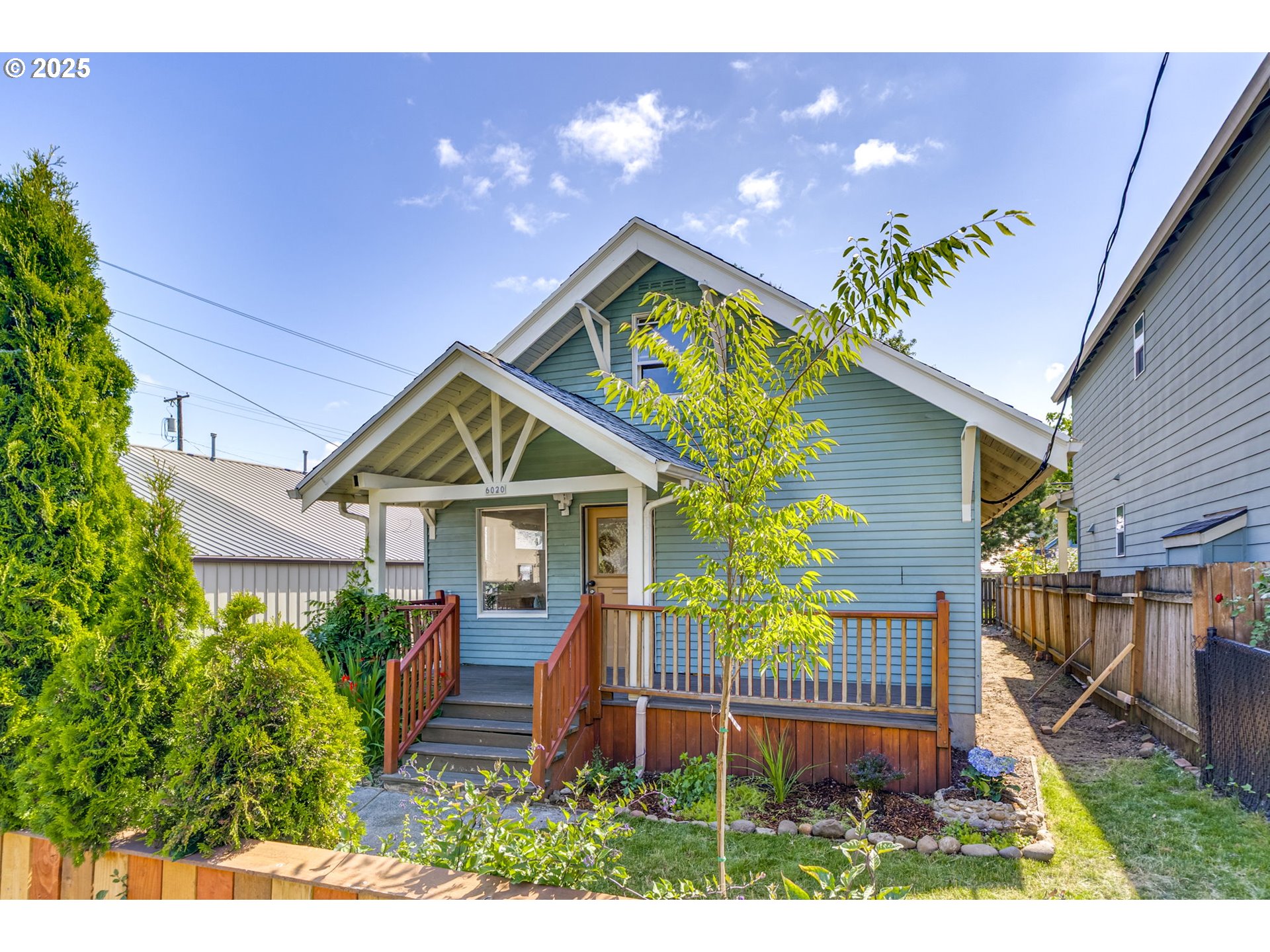 6020 Southeast 83rd Avenue Portland, OR 97266 - Photo 2 of 46 a front view of a house with a yard and potted plants