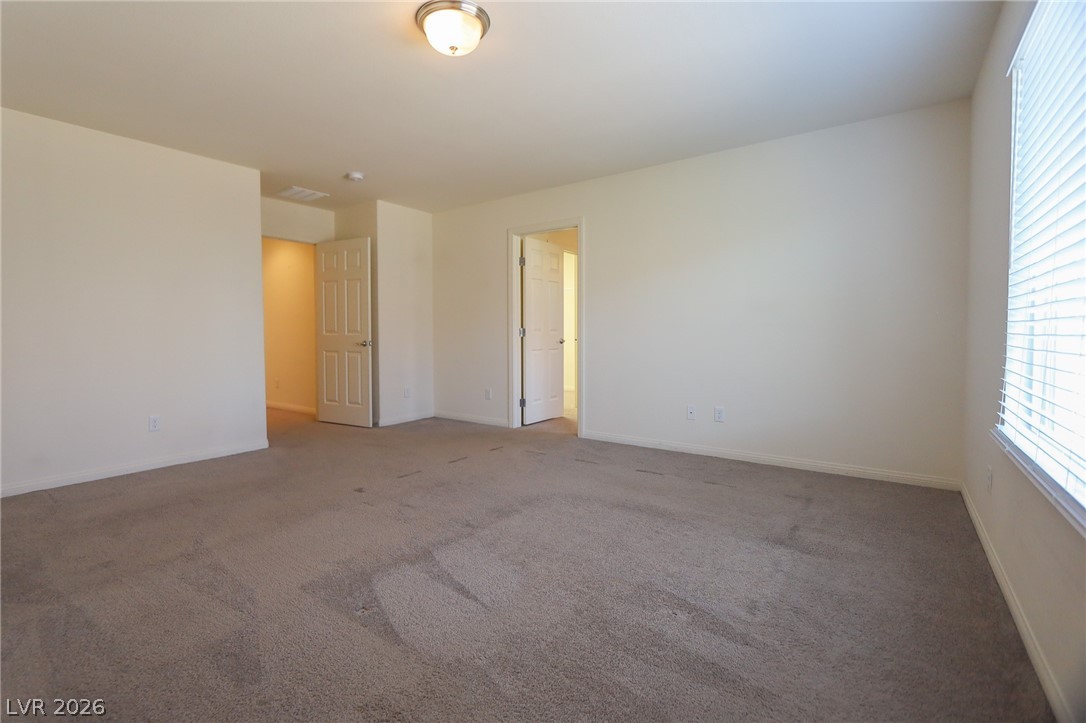 6418 Jackson Spring Road Las Vegas, NV 89118 - Photo 2 of 20 A spacious, naturally illuminated room featuring plush carpeting and neutral walls, offering versatile living.