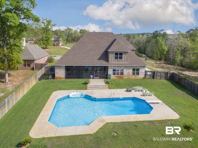 7814 Balin Drive Daphne, AL 36527 - Photo 2 of 26 Sprawling fenced yard with a natural backdrop,a pool and lounge area and a screened porch for great outdoor living or entertaining!