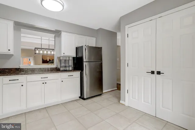 a kitchen with a refrigerator sink and cabinets