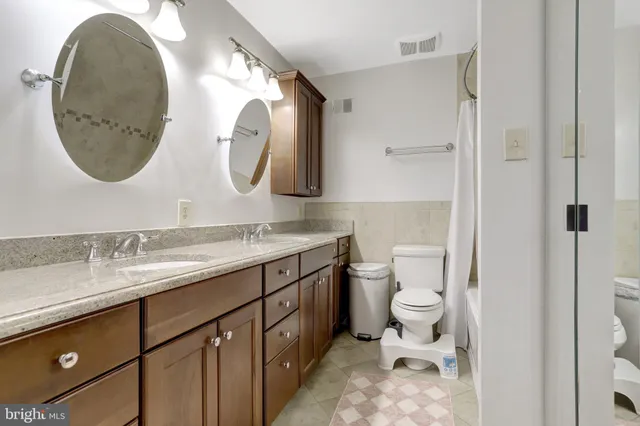a bathroom with a granite countertop toilet sink and mirror