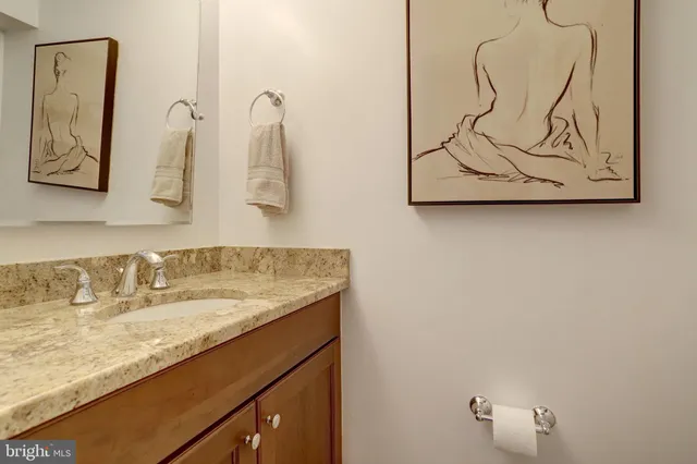 a bathroom with a granite countertop sink and a mirror
