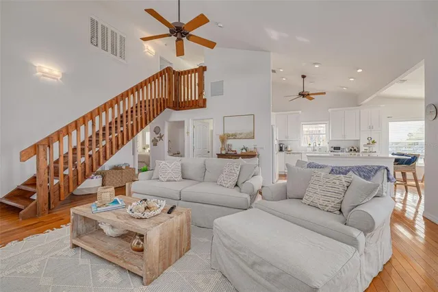 a living room with furniture or wooden floor and a view of kitchen