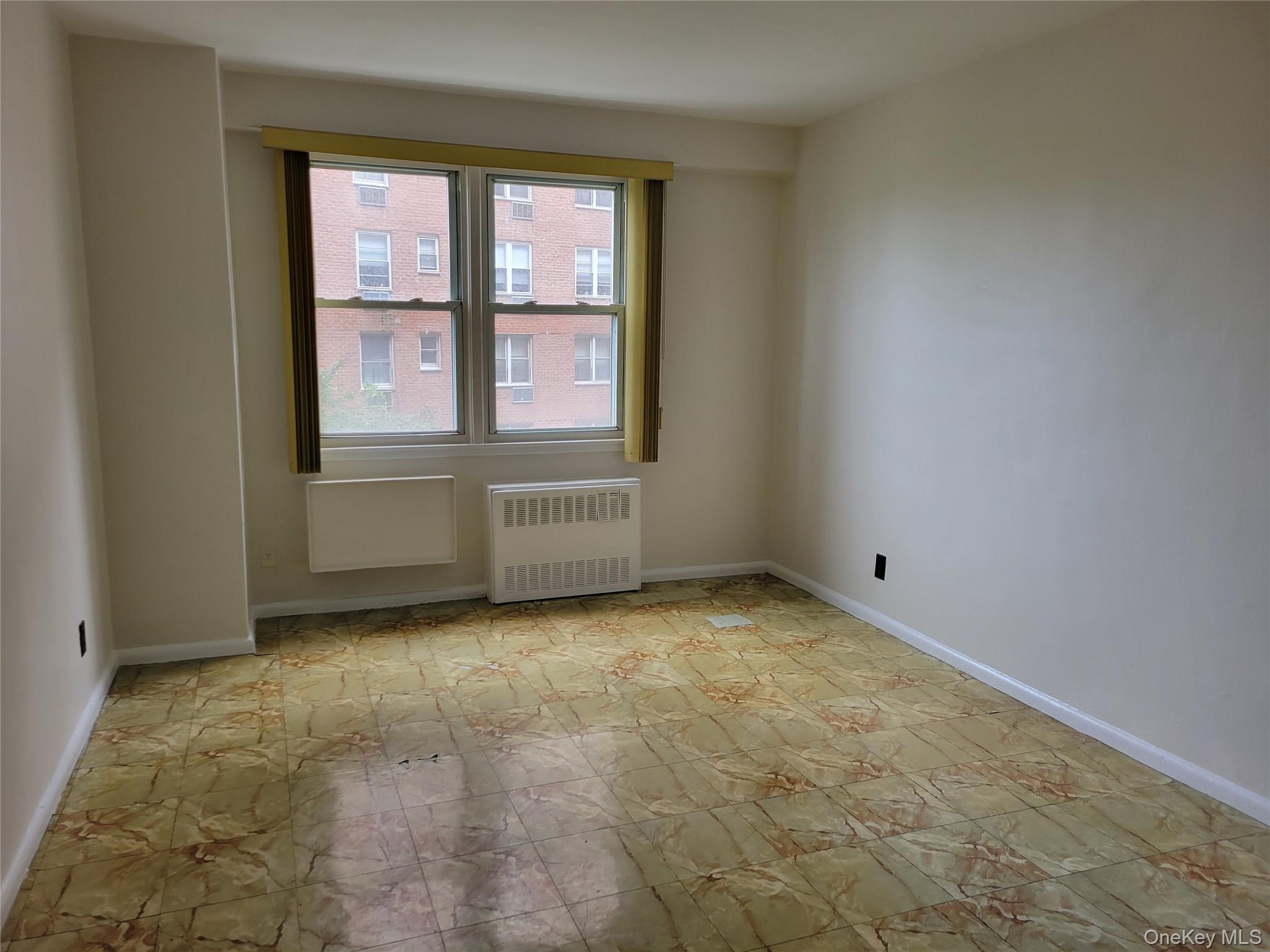 138-10 Franklin Avenue, Unit 5H Queens, NY 11355 - Photo 7 of 8 an empty room with windows