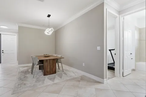 a kitchen with kitchen island granite countertop a table chairs microwave and refrigerator