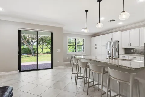 a kitchen with stainless steel appliances granite countertop a sink refrigerator and cabinets