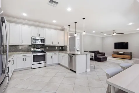 a bathroom with a granite countertop sink a large mirror and a window