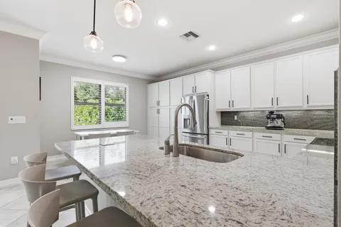 a kitchen with stainless steel appliances granite countertop a sink refrigerator and cabinets