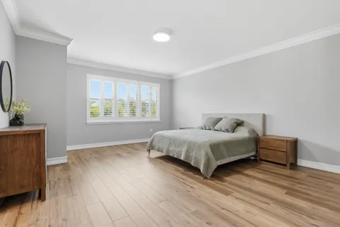 a bedroom with a bed and wooden floor