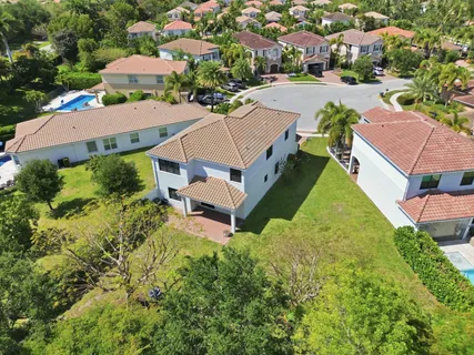 an aerial view of a house with a garden and lake view
