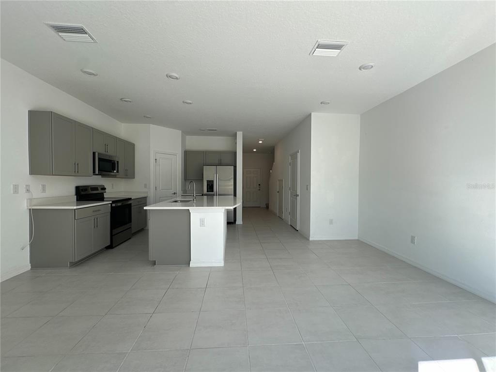 2416 Paravane Way Wesley Chapel, FL 33543 - Photo 13 of 35 a view of a kitchen with a sink and dishwasher a oven with wooden floor