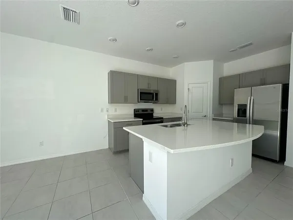 a view of a kitchen with a sink a refrigerator and a stove