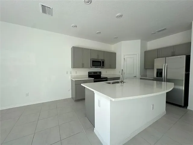 a view of a kitchen with a sink a refrigerator and a stove
