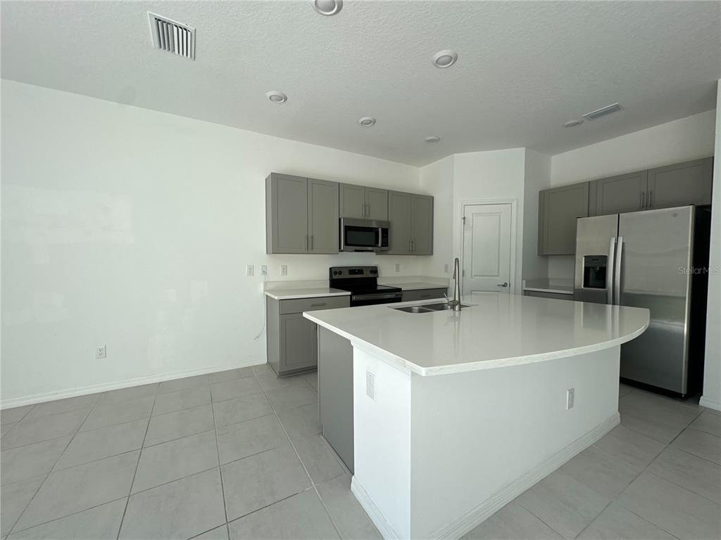 2416 Paravane Way Wesley Chapel, FL 33543 - Photo 16 of 35 a view of a kitchen with a sink a refrigerator and a stove