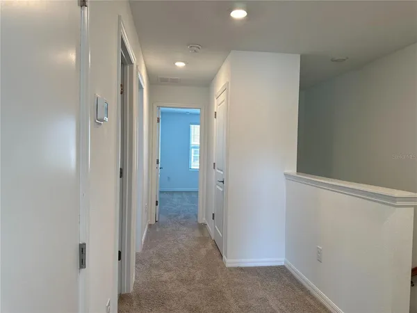 a view of a hallway with wooden shelves