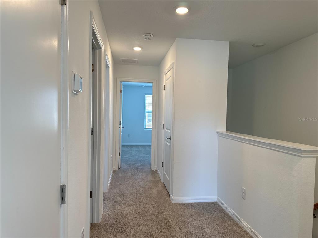 2416 Paravane Way Wesley Chapel, FL 33543 - Photo 21 of 35 a view of a hallway with wooden shelves