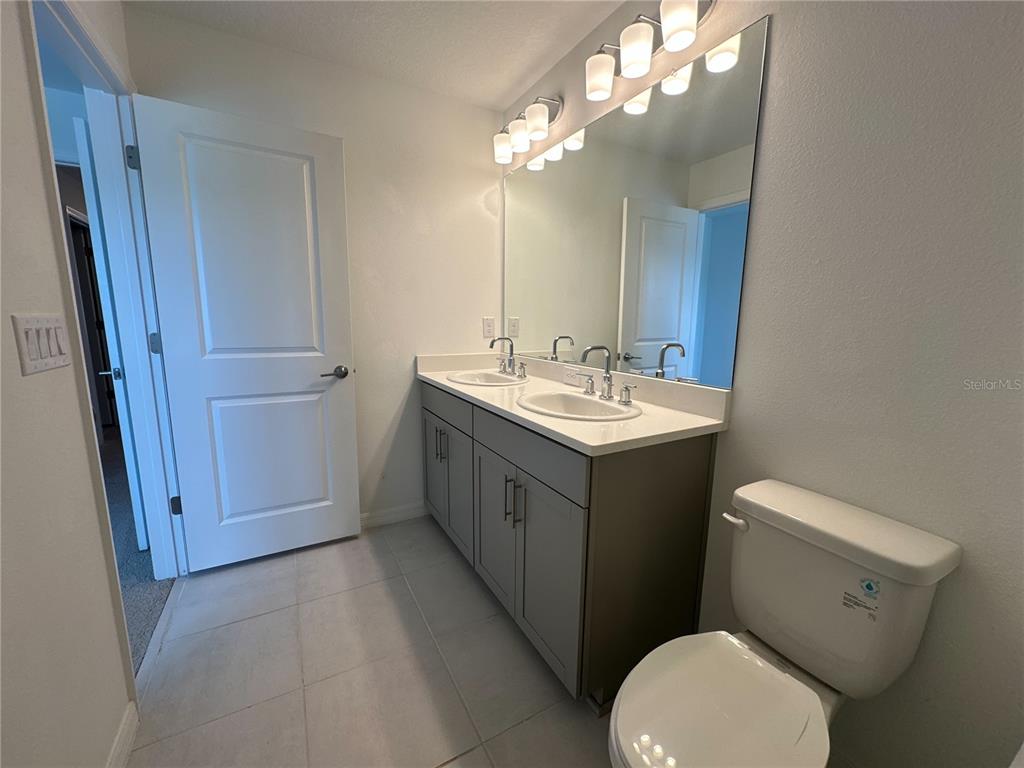 2416 Paravane Way Wesley Chapel, FL 33543 - Photo 23 of 35 a bathroom with a toilet sink and mirror