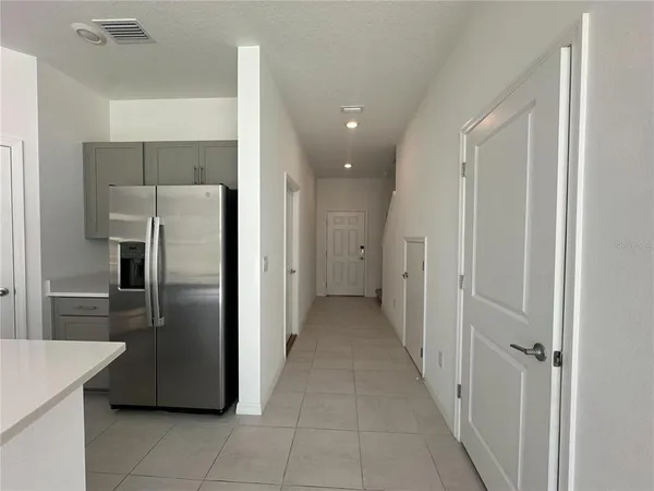 a view of a kitchen with a refrigerator and a sink