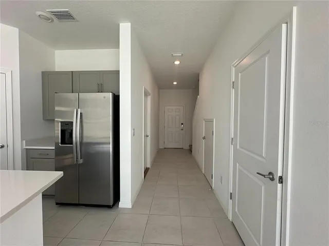 a view of a kitchen with a refrigerator and a sink