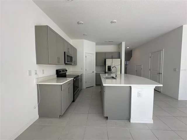 a kitchen with a sink a counter top space stainless steel appliances and cabinets