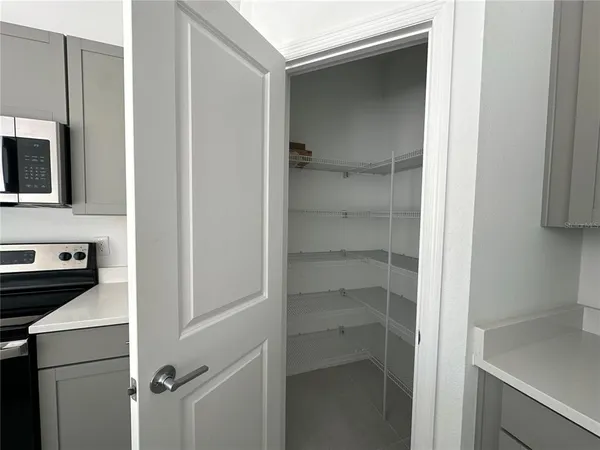 a kitchen with a refrigerator and white cabinets