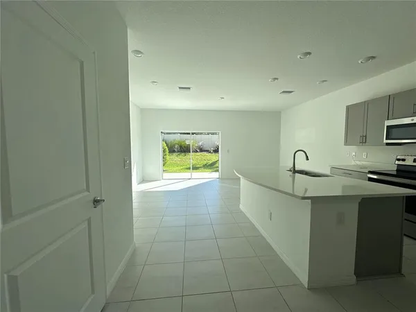 a view of a kitchen with a sink a refrigerator and window