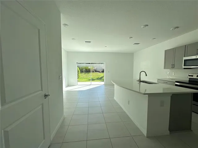 a view of a kitchen with a sink a refrigerator and window
