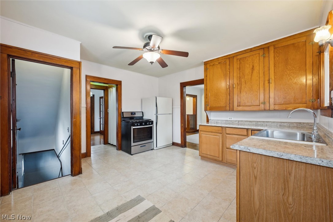 64 West Bagley Road Berea, OH 44017 - Photo 17 of 48 Kitchen with white fridge, light tile flooring, ceiling fan, stainless steel gas stove, and sink