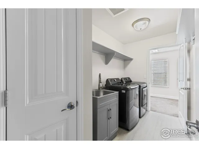 a view of a hallway with staircase and white walls