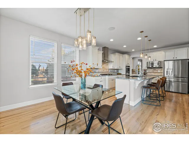 a dining room filled chandelier and wooden floor