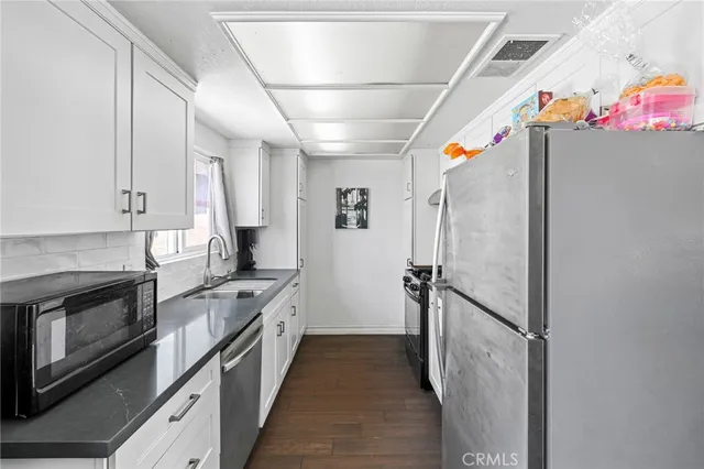 a kitchen with granite countertop a stove and a refrigerator