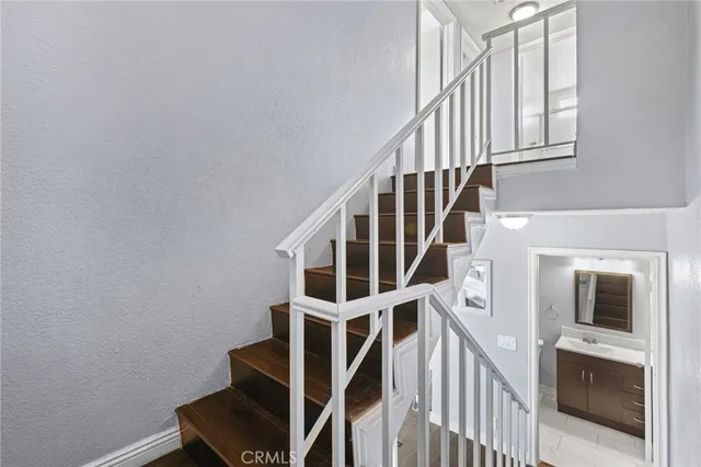 a view of staircase with wooden floor and white walls