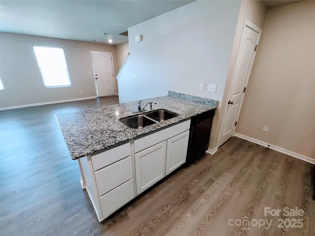 a kitchen with granite countertop a sink and a stove top oven