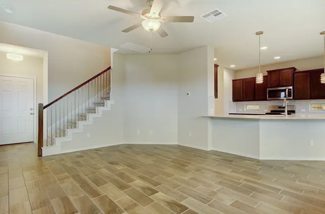 a view of kitchen with stainless steel appliances granite countertop a stove a sink and a refrigerator