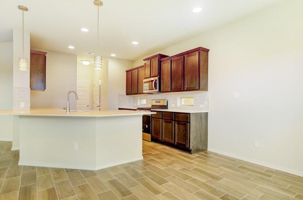 3453 Pauling Loop Round Rock, TX 78665 - Photo 6 of 28 a large kitchen with kitchen island granite countertop a large counter top and sink