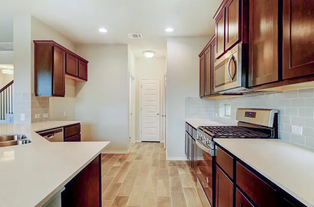 a kitchen that has a lot of cabinets and wooden floor