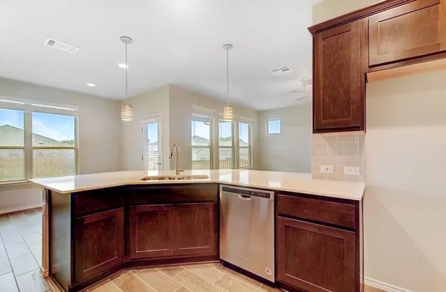 a kitchen with a sink a center island and a window