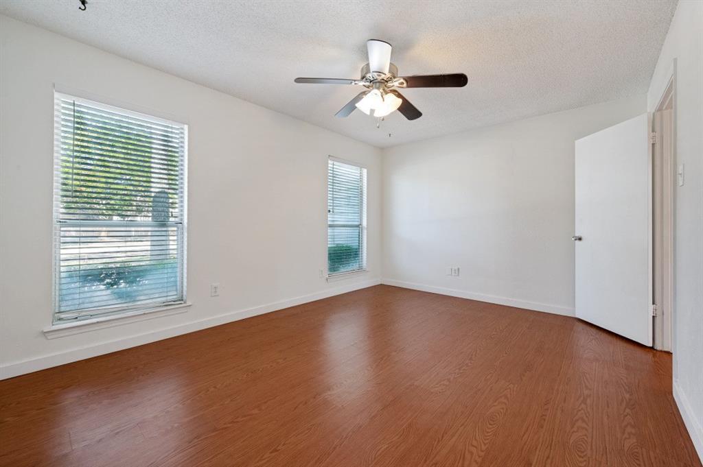 9206 Rodeo Drive Irving, TX 75063 - Photo 11 of 25 a view of an empty room with wooden floor and a window