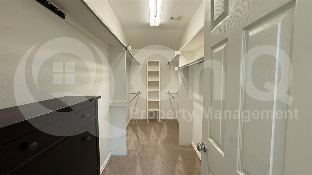18240 Midway Road, Unit 1204 Dallas, TX 75287 - Photo 20 of 27 Walk-in closet featuring carpeted flooring, built-in shelving, and multiple hanging rods for organization
